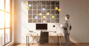 A businessman looking at a 12-month calendar or planning board outlining the steps to prepare a business for sale.