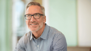 A decision scale balancing a "Sell Now" sign and a "Wait and Build Value" sign with a 2026 calendar in the background.